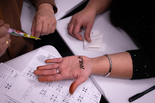 Cree syllabics applied to a Building Bridges participants arm using henna. 